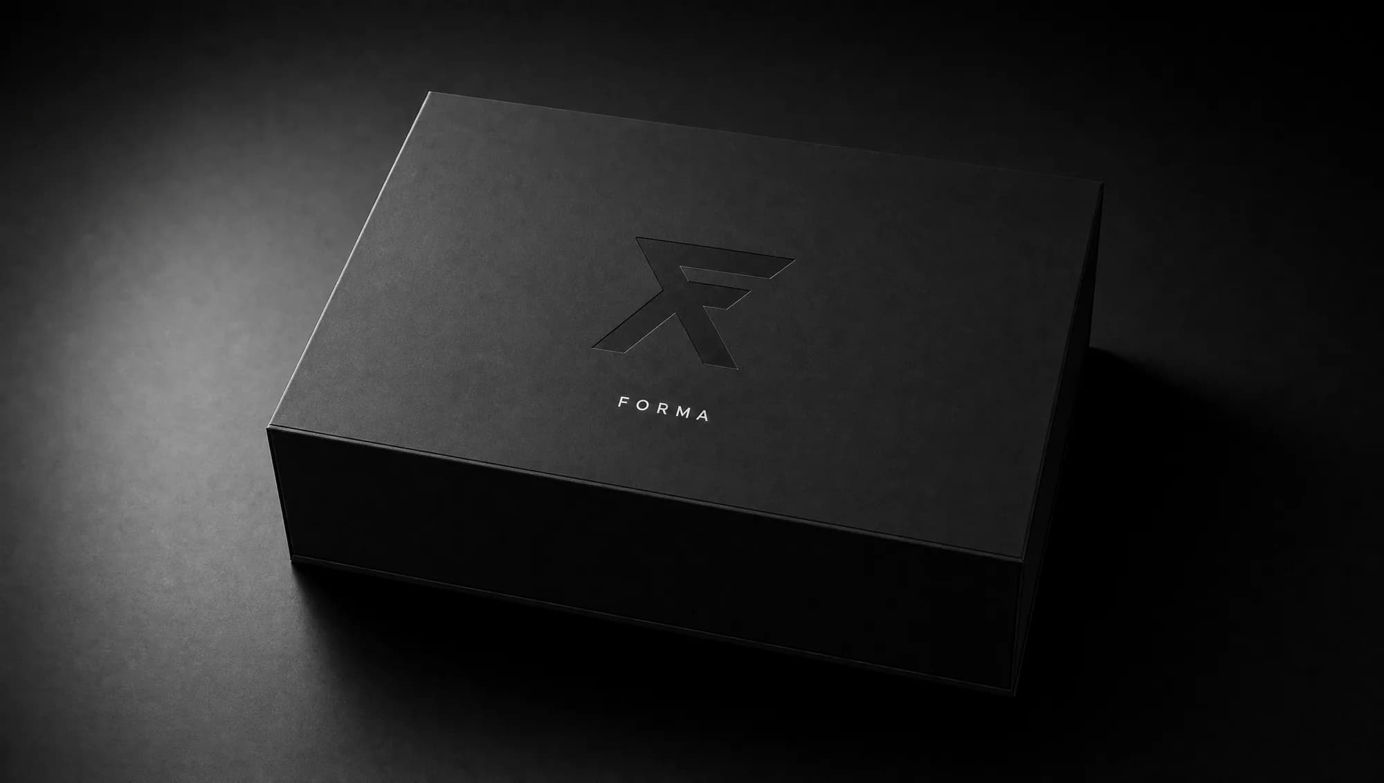 The FORMA box closed, matte black with a blind-debossed F emblem and white wordmark.