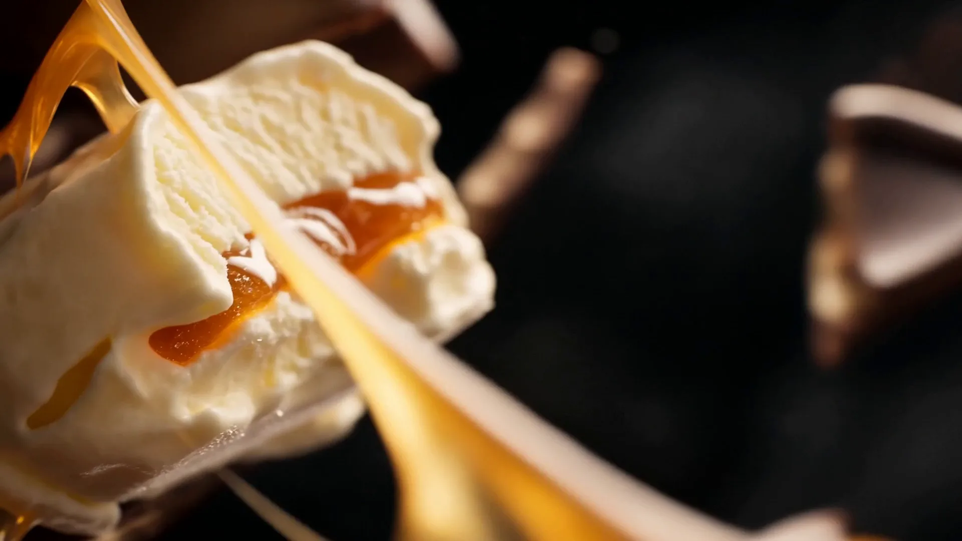 The reveal: velvet vanilla ice cream with a caramel ribbon, close on the lens.